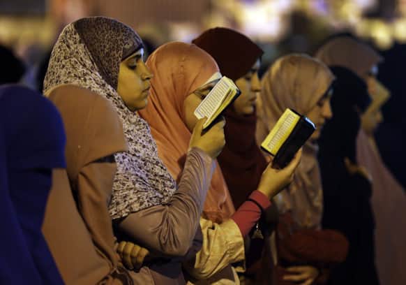 Supporters of Egypt`s ousted President Mohammed Morsi read verses from Islam`s holy book the Quran as they pray the Tarawih prayer, after the evening meal when Muslims break their fast during the Islamic month of Ramadan.