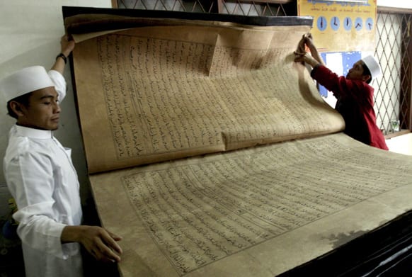 Teachers show a giant Quran displayed at Al-Ashriyyah Nurul Iman boarding school in Parung,West Java, Indonesia.