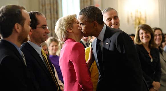 Sen. Elizabeth Warren, D-Mass., left, gets a kiss from President Barack Obama following a statement with Richard Cordray, the new director of the Consumer Financial Protection Bureau, in the State Dining Room of the White House in Washington.