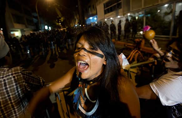 An indigenous woman shouts slogans against Rio de Janeiro`s Gov. Sergio Cabral during a protest near his home, in Rio de Janeiro, Brazil.