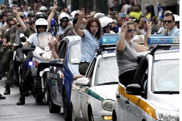 Municipal police officers gesture as they participate in a anti-austerity rally outside the Greek parliament in central Athens. Anti-austerity protests have been taking place in Athens ahead of the Greek parliament`s vote to introduce thousands of public-sector job cuts and transfers.