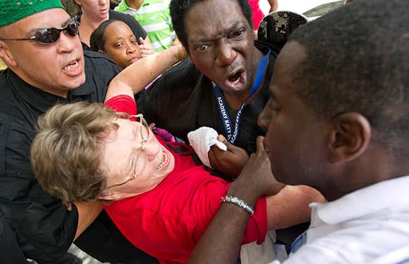 Friends try to calm down, David Wright, top, who reacted after he was told he couldn`t enter the Bob Casey Federal Courthouse in Houston as more than 100 protestors organized outside for a protest in reaction to the acquittal of neighborhood watch member George Zimmerman.