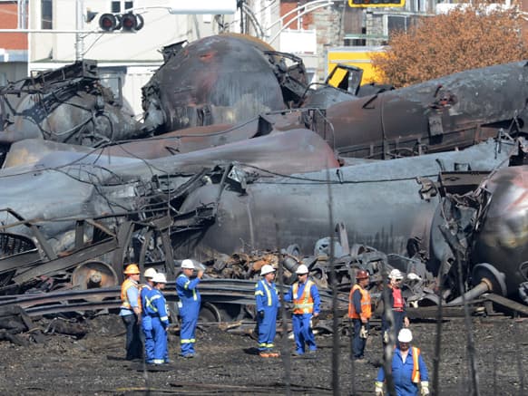 Emergency workers examine the aftermath of a train derailment and fire in Lac-Megantic, Quebec. Thirty-seven bodies have been recovered and another 13 people missing are still missinfg after the July 6, 2013, derailment.