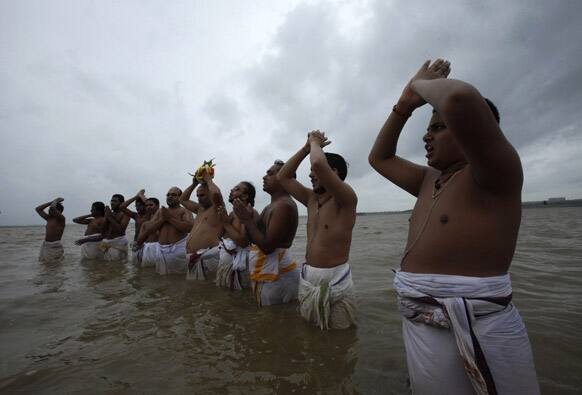 Hindu priests offer prayers to Varuna, the Hindu god of rain standing in the waters of at the Osman Sagar Lake on the outskirts of Hyderabad.