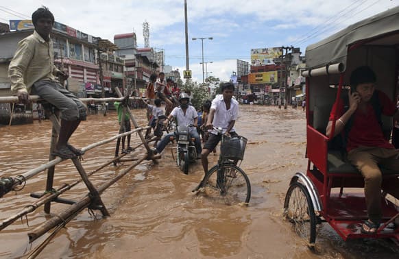 People move through a waterlogged street in Guwahati. Heavy showers flooded some areas in the city on Tuesday.