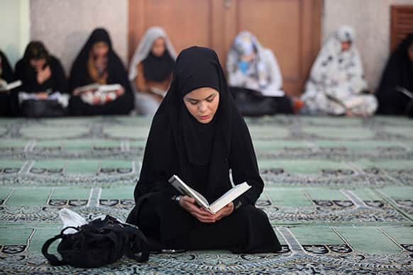 An Iranian woman recites verses from the Quran during the Muslim holy month of Ramadan at a mosque in Tehran, Iran.