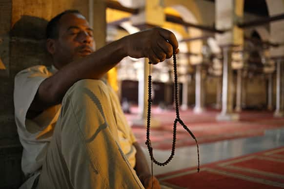An Egyptian man uses prayer beads as he waits for the afternoon prayer at al-Azhar mosque during the Muslim holy month of Ramadan in Cairo, Egypt.