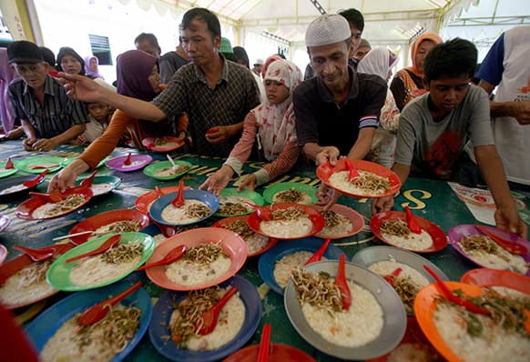 Officials prepare meals provided free for Muslim devotees to break their fast at a mosque in Medan, North Sumatra, Indonesia.