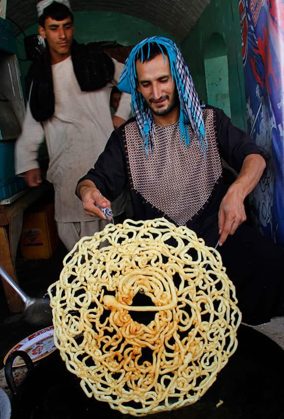 An Afghan worker makes sweets at a traditional factory ahead of the Islamic holy month of Ramadan in Kandahar southern of Kabul, Afghanistan.