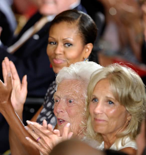 Former first lady Barbara Bush, center, sits with first lady Michelle Obama, top, and Jill Biden, right, wife of Vice President Joe Biden, during a ceremony to recognize the 5,000th Daily Point of Light Award in the East Room of the White House in Washington.