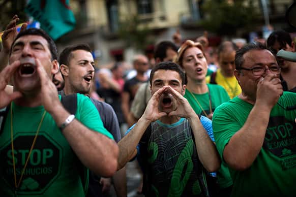 Demonstrators shout slogans against the government in front of the delegation of the Spanish government in Catalonia during a protest in Barcelona, Spain.