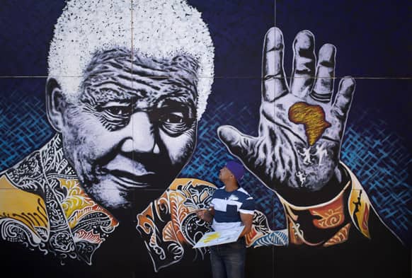 South African artist John Adams works on a giant acrylic-on-canvas painting of Nelson Mandela in the driveway of his house in a suburb of Johannesburg, South Africa.