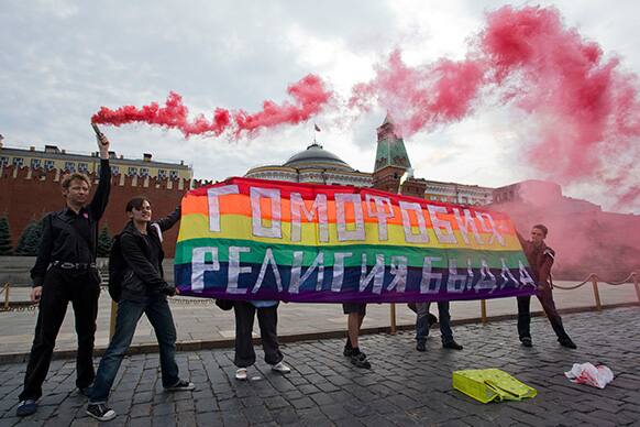 Gay rights activists hold a banner reading