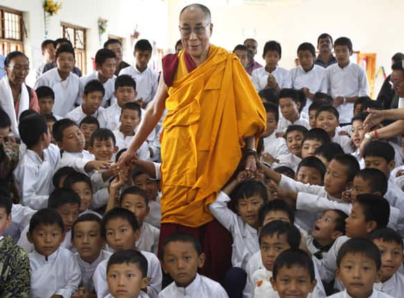 Tibetan spiritual leader the Dalai Lama poses for a photo with students of a Tibetan school after inaugurating its auditorium in Gurupura 210 kilometers (131 miles) southwest of Bangalore.