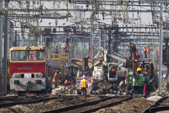Railway company employees work at a site of a train accident at a station in Bretigny sur Orge, south of Paris.