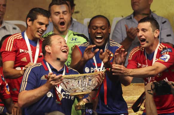 CSKA Moscow`s team coach Leonid Slutskiy, holds a trophy as his players Mark Gonzalez, Igor Akinfeev, Vagner Love and Alan Dzagoev, celebrate their victory against Zenit St. Petersburg`s team during the Russian Super Cup soccer match in Rostov-on-Don, southern Russia.