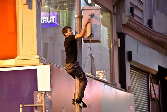 A youngster destroys a surveillance camera on Istiklal avenue, the main shopping street of Istanbul, during clashes between riot police and anti-government demonstrators in Istanbul, Turkey.