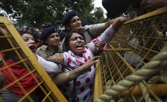 Policewomen try to stop a supporter of India`s main opposition Bharatiya Janata Party from scaling a police barricade during a protest against rising inflation in New Delhi.