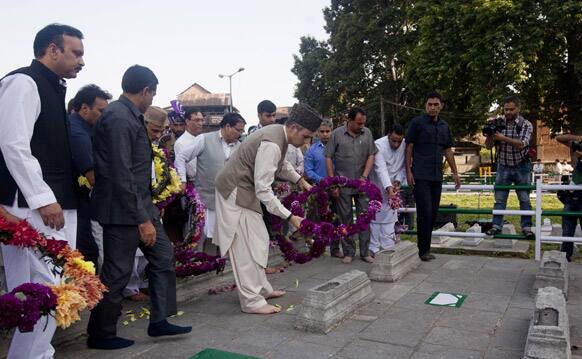 Jammu and Kashmir Chief Minister Omar Abdullah, wearing a brown cap, lays a wreath on a grave at Martyrs` Graveyard in Srinagar.