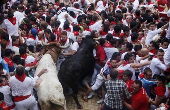 Runners trip and fall ahead of the bulls blocking the entrance to the bullring during the running of the bulls of the San Fermin festival, in Pamplona, Spain.