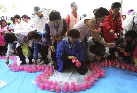 South Korean place candles on a reunification flag during a joint memorial service to commemorate upcoming the 60th anniversary of the signing of the armistice agreement that ended the Korean War on July 27, 1953, in Hwacheon.
