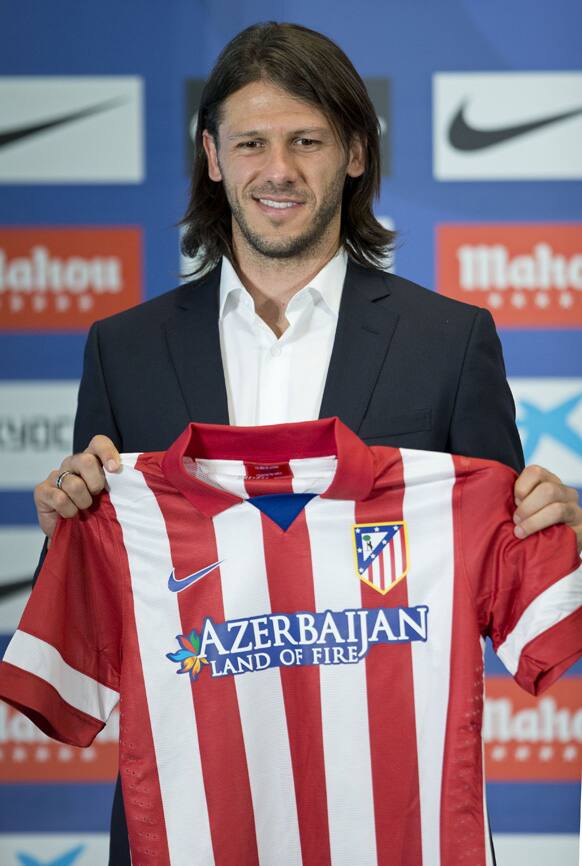 Martin Demichelis of Argentina holds up his new shirt during his presentation at the Vicente Calderon stadium in Madrid, Spain after signing for Atletico Madrid.