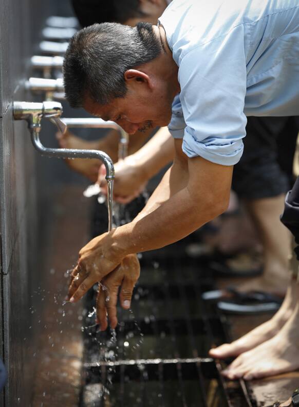 A man washes his hands before entering a mosque for Friday prayers during the holy fasting month of Ramadan in Kuala Lumpur, Malaysia.