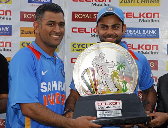 Mahendra Singh Dhoni and teammate Virat Kohli hold the trophy after winning the final match of the Tri-Nation cricket series in Port-of-Spain, Trinidad. India beat Sri Lanka by one wicket with two balls remaining.