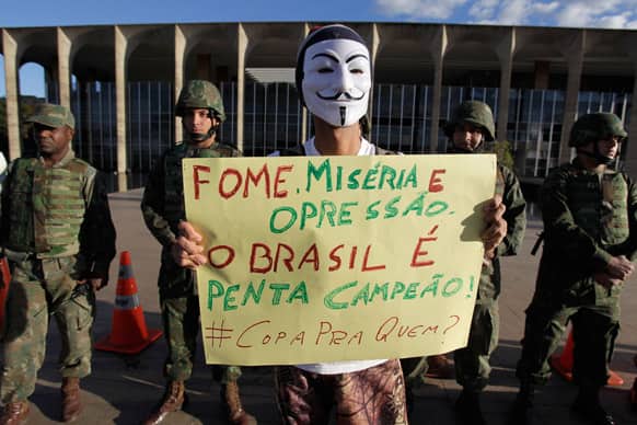 A demonstrator holds up a banner that reads in Portuguese
