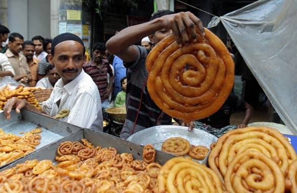 A Bangladeshi vendor displays traditional food items as Muslims crowd the area to break their fast on the first day of Ramadan in Dhaka.