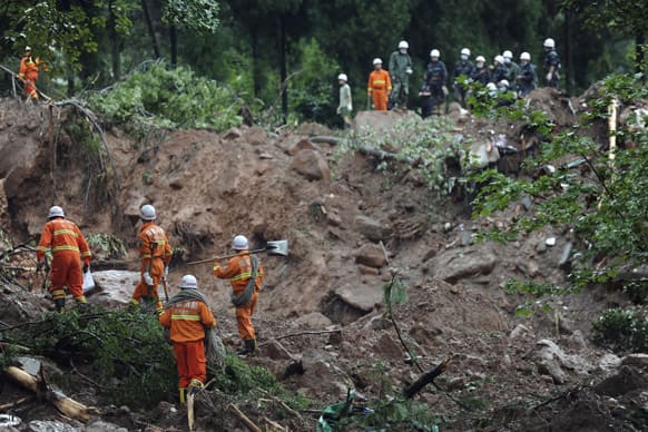Rescue workers walk at the site of a massive landslide caused by heavy rains near Dujiangyan city in southwestern China`s Sichuan province. Flooding in the western province of Sichuan was the worst in 50 years for some areas, with more than 100,000 people forced to evacuate.