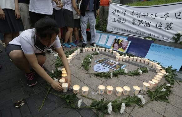 South Korean students light candles during a candlelight vigil to mourn the deaths of the two Chinese victims who died in a Asiana Airlines plane crash in San Francisco, in Seoul, South Korea.