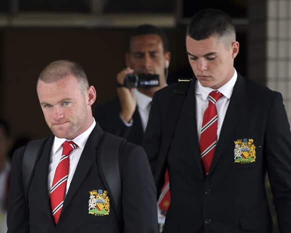 Players of Manchester United football club, Wayne Rooney, Rio Ferdinand, with camera, and Michael Keane walk out of the VIP terminal shortly after arrival at Don Muang airport in Bangkok, Thailand.