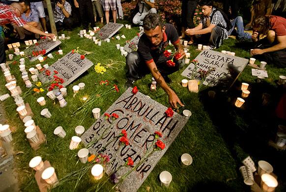 People light candles and place flowers on a makeshift memorial for the victims of clashes between protesters and riot police during a rally in Gezi Park in Istanbul, Turkey.