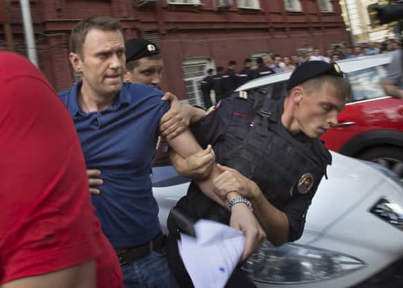 Police officers detain Russian opposition leader Alexei Navalny, left, in Moscow, Russia. Navalny was briefly detained by police after he spoke to a crowd of supporters outside the headquarters of Moscow`s election commission.