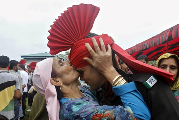 A woman kisses the forehead of her son after he was inducted as a soldier of the Jammu and Kashmir Light Infantry during a graduation parade at a military base on the outskirts of Srinagar.