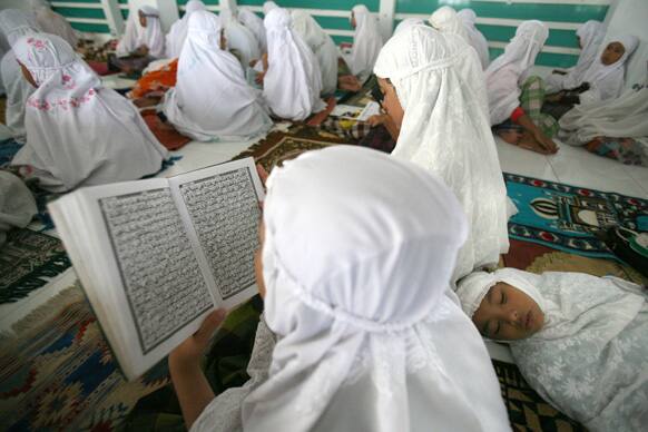 Students read the Quran on the first day of the holy fasting month of Ramadan, at Ar-Raudlatul Hasanah Islamic boarding school in Medan, North Sumatra, Indonesia.