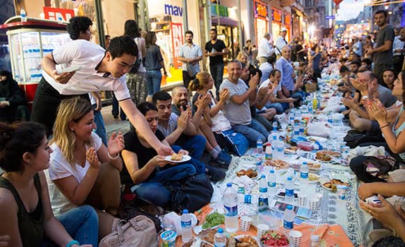Thousands of people sit on Istiklal Avenue, the main shopping road of Istanbul, in Istanbul, Turkey.