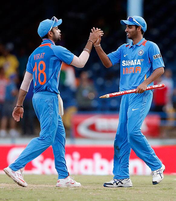 India acting captain Virat Kohli, left, high fives bowler Bhuvneshwar Kumar after beating Sri Lanka in their Tri-Nation Series cricket match in Port-of-Spain, Trinidad.