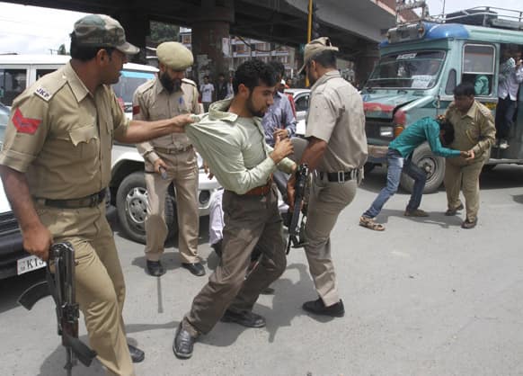 Policemen detain Kashmiri government employees during a protest in Srinagar. The protesters were demanding regularization of contractual jobs and a hike in salary.