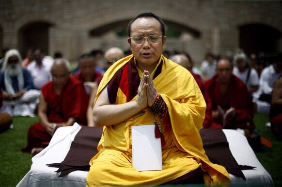 Tibetan Buddhist monks pray for peace following a series of blasts in Bodh Gaya on Sunday at Rajghat, a memorial to Mahatma Gandhi, in New Delhi.