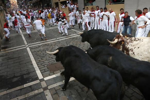 Revelers run in front of Valdefresno ranch fighting bulls during the San Fermin fiestas, in Pamplona, Spain.
