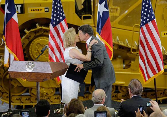 Texas Gov. Rick Perry kisses his wife, Anita at Holt Cat, in San Antonio, Texas where announced he will not seek reelection.