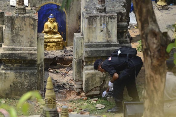 National Security Guard soldier collects the evidence from the site a blast at the Mahabodhi Temple or the great Awakening Temple complex, in Bodhgaya.