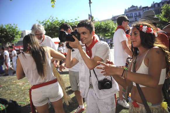 Michael Hemingway, 16, centre, Ernest’s Hemingway`s great-grandson, takes photos at the San Fermin fiestas, in Pamplona northern Spain.