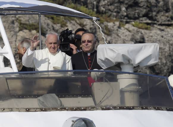 Pope Francis waves to faithful aboard an Italian Coast Guard boat upon his arrival at the island of Lampedusa, southern Italy.