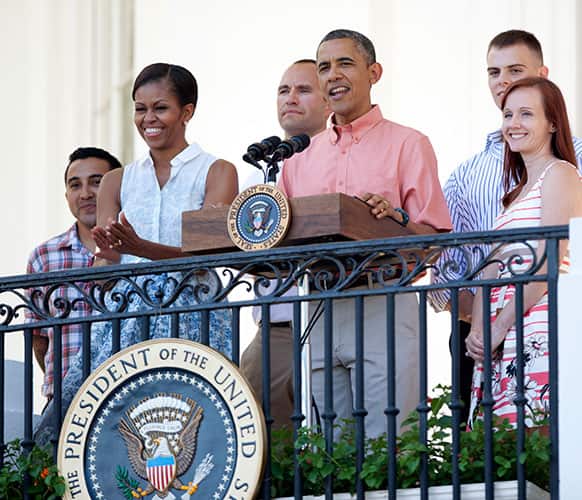President Barack Obama with first lady Michelle Obama and members of the military, speaks during a Fourth of July celebration on the South Lawn of the White House in Washington.