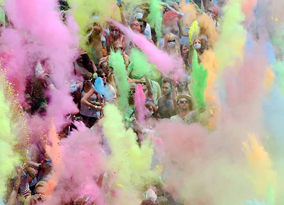 Visitors of the Holi Festival of Colours throw special colored powders in the air on a meadow near Karlsruhe, Germany.