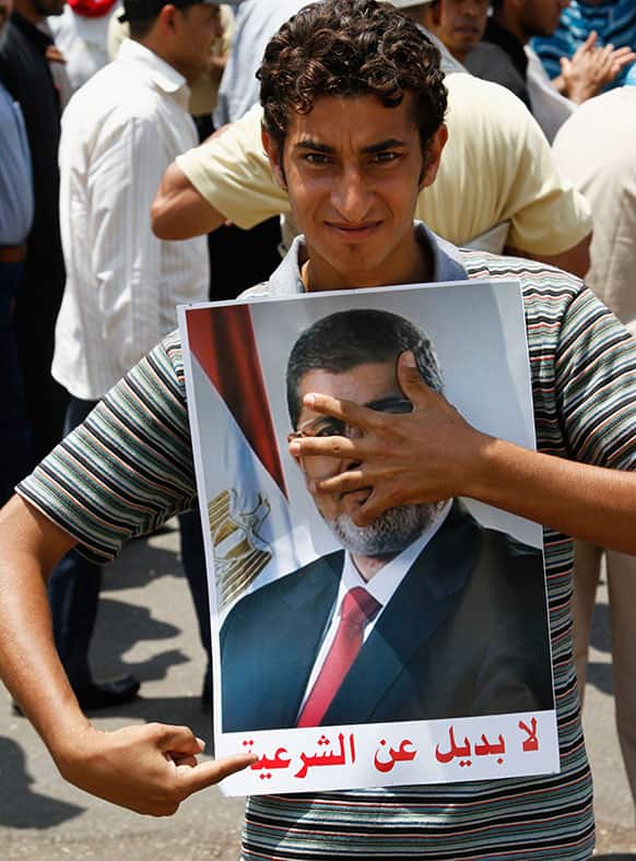 A supporter of Egypt`s ousted President Mohammed Morsi holds his portrait with the slogan