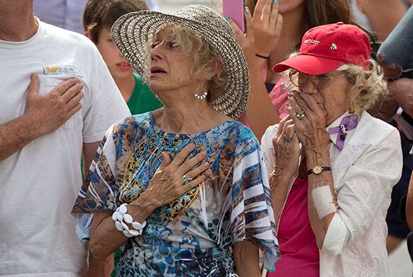 Two women react as as 19 hearses slowly roll by, in downtown Prescott, Ariz., carrying the 19 Granite Mountain Hotshot firefighters killed a week ago by an out-of-control blaze near Yarnell, Ariz.